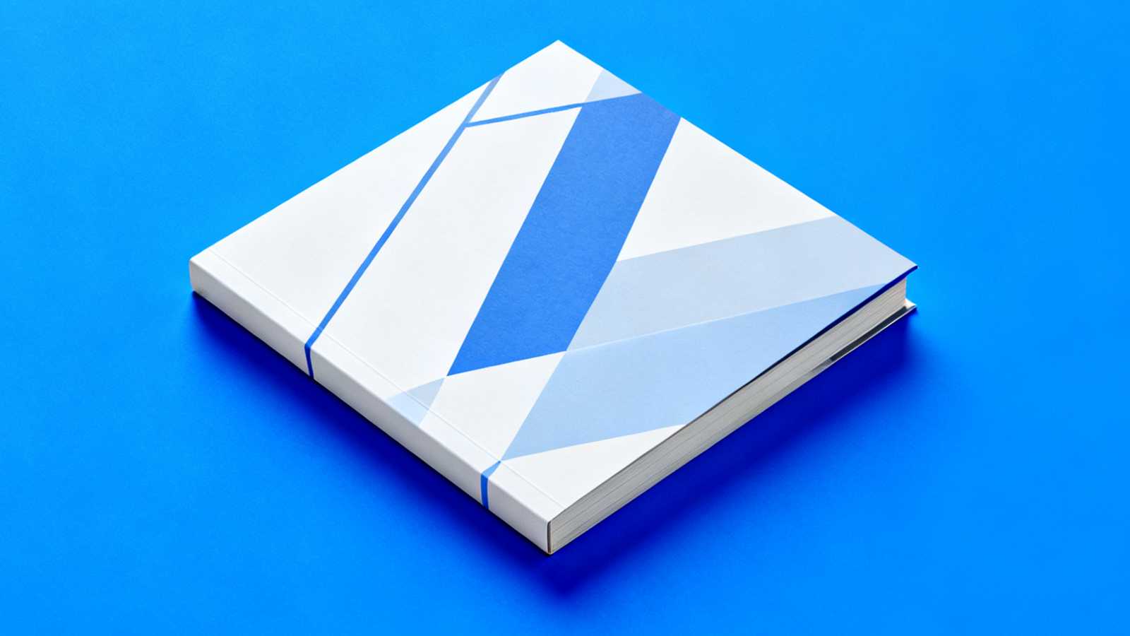 Minimalist square book mockup template on blue background.