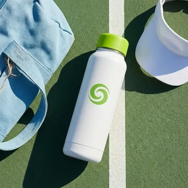A white bottle with a green cap in a sports flat lay