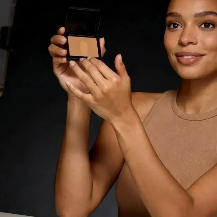A model presenting a makeup compact